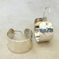Pair of silver hoop earrings on a light beige background