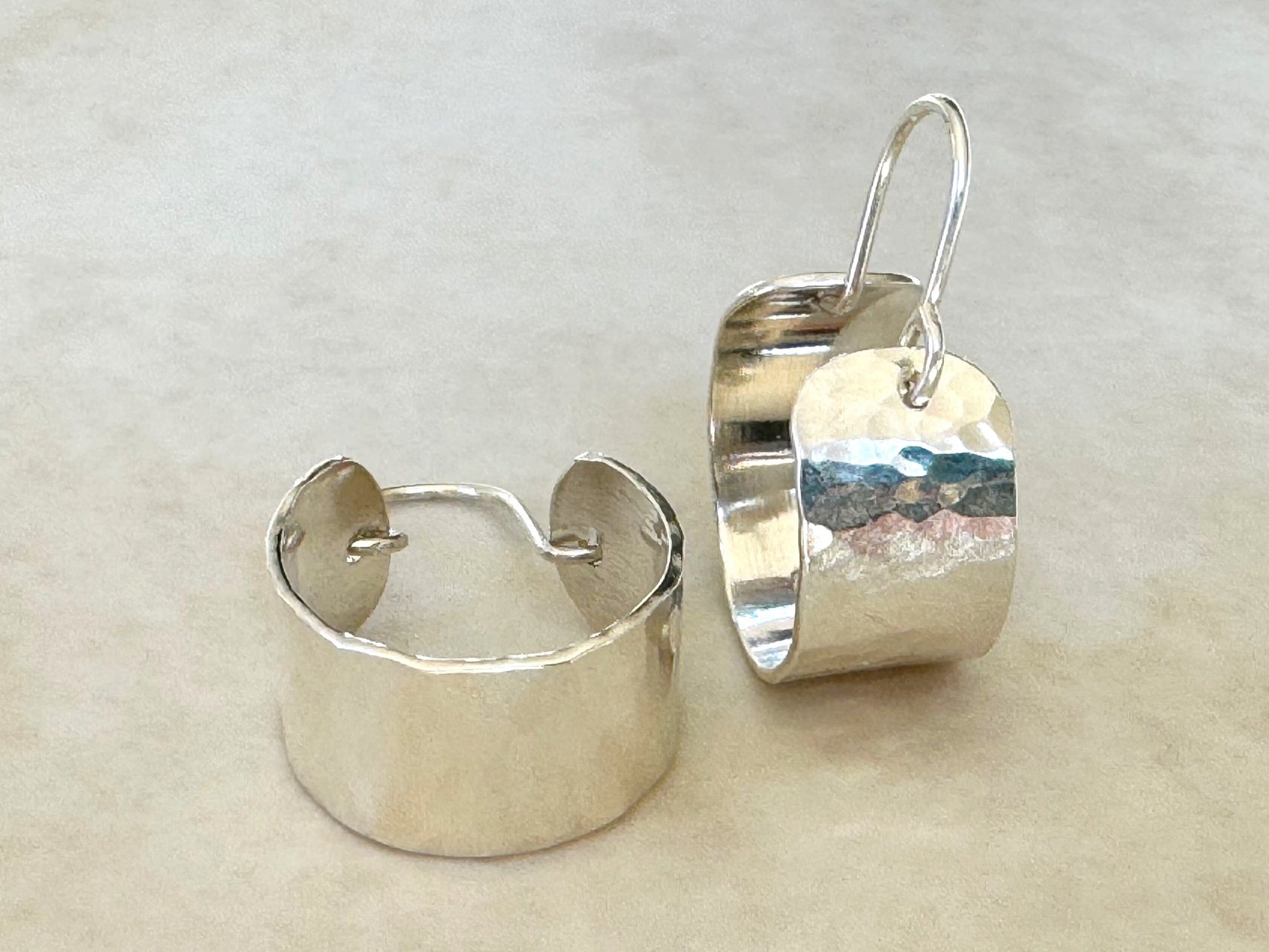 Pair of silver hoop earrings on a light beige background