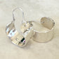 Pair of silver hoop earrings on a beige background