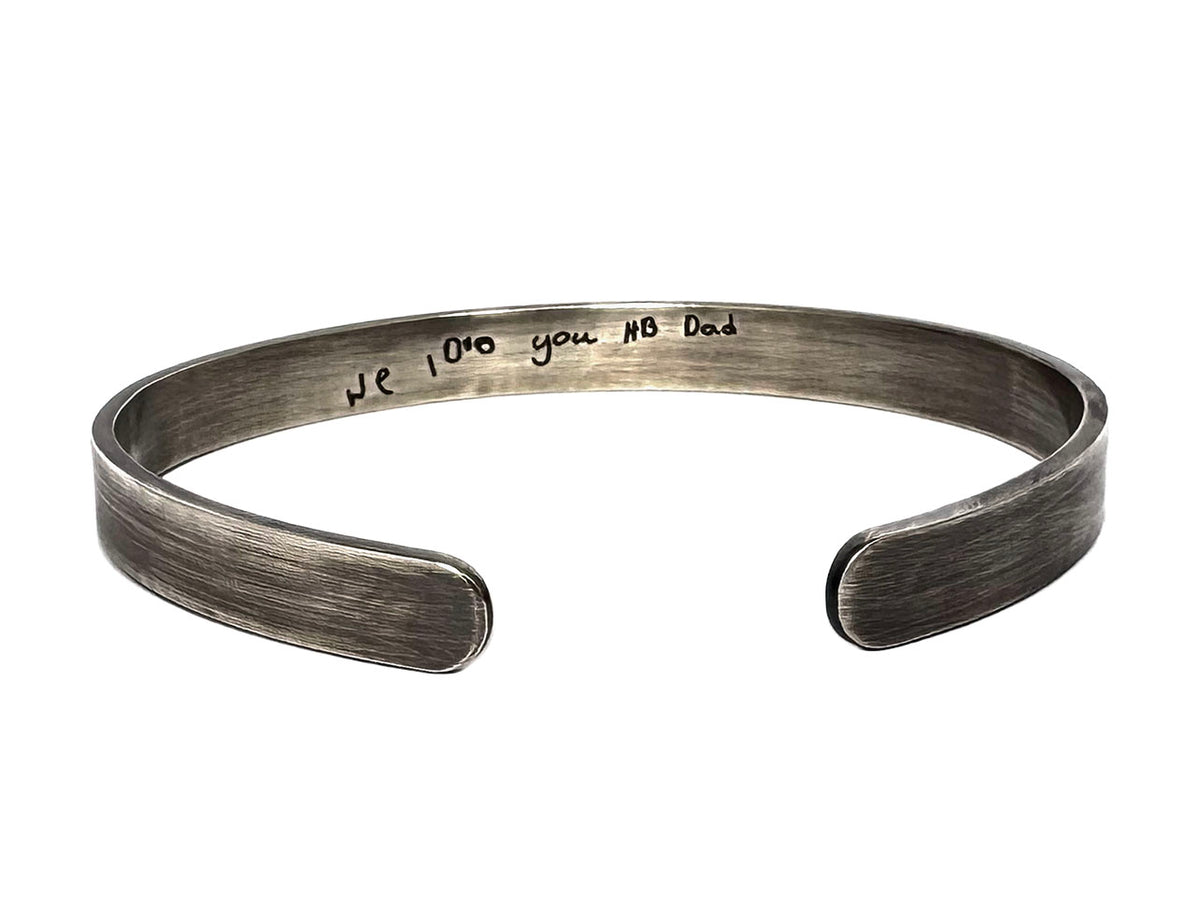 Sterling silver cuff bracelet with a handwritten message engraved in the customer's child's own handwriting - 'We love you HB Dad'