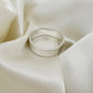 Flat sterling silver wedding ring with a brush finish against a cream satin background - Rebecca Cordingley Jewellery