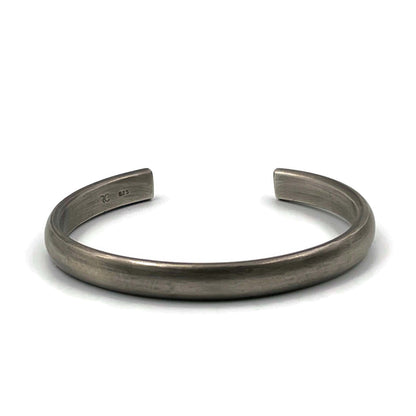 Heavy half-round sterling silver cuff bracelet with an oxidised finish on a white background.