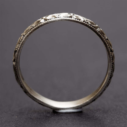 A sterling silver flower stacking ring on a dark grey background