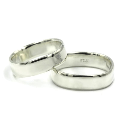 Pair of square sterling silver wedding rings with bevelled edges, handmade in Australia, laying flat on white background