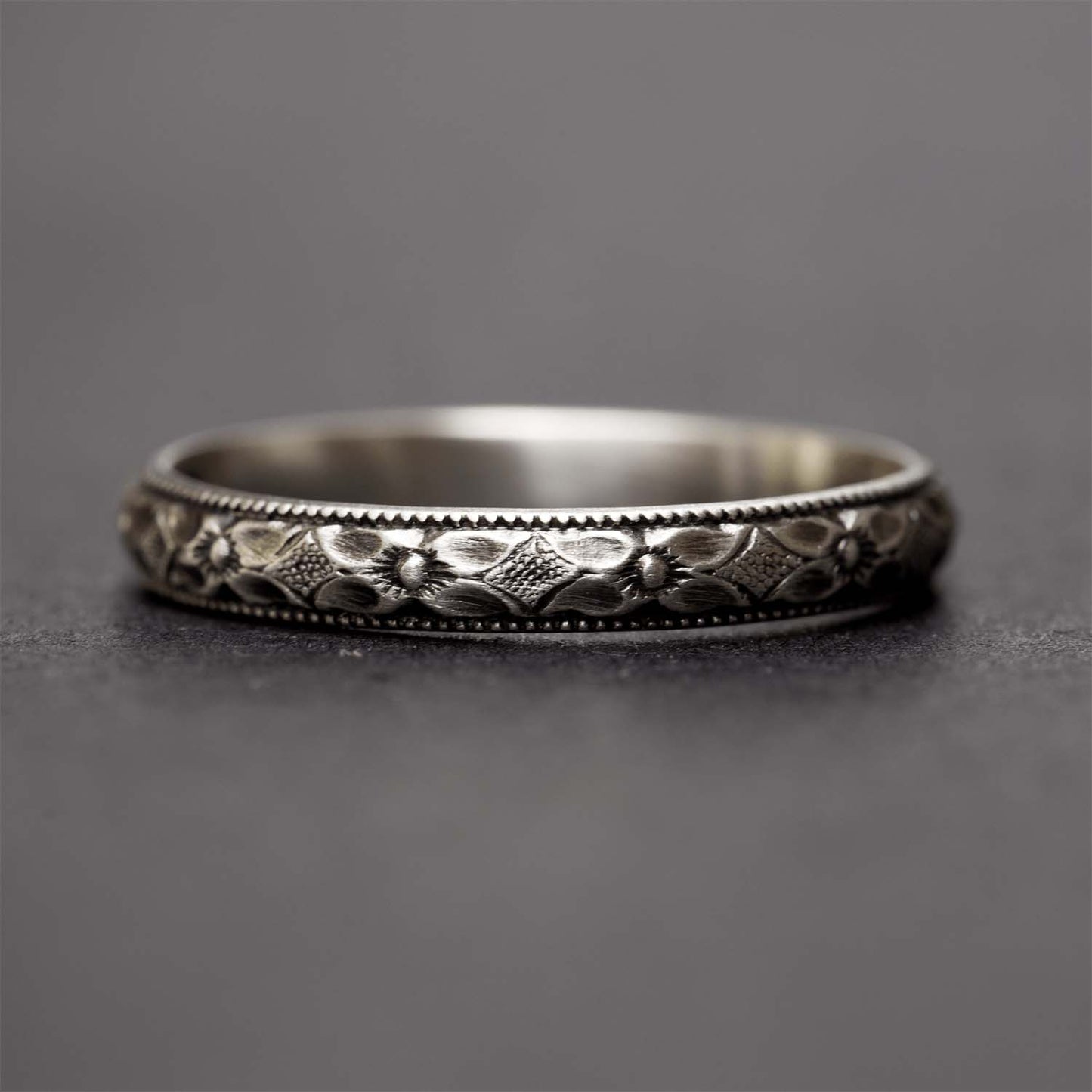 Sterling silver flower ring for women on a dark grey background