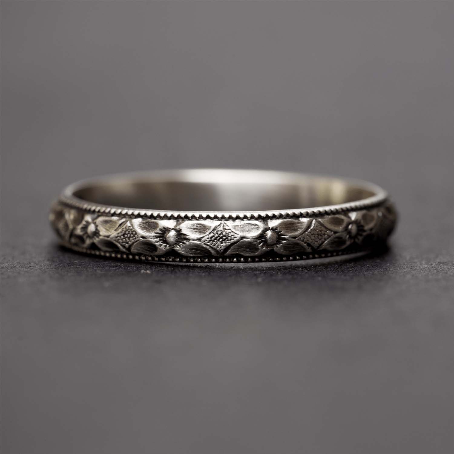 Sterling silver flower ring for women on a dark grey background
